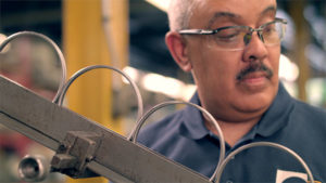 Working looking at production line for ball bearing assemblies